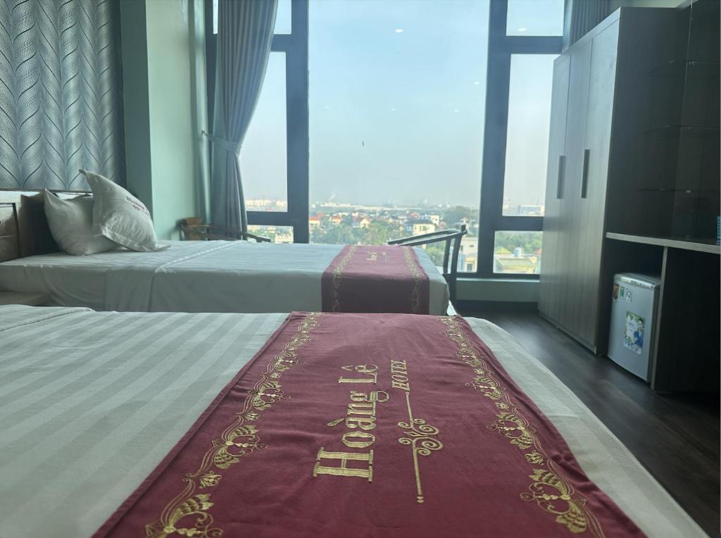 a hotel room with two beds and a red carpet at Hotel Hoàng Lê Tiền Hải in Tiền Hải