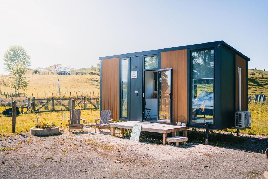 HuiroaStone Cabin by Tiny Away的一个小房子,有长凳和桌子