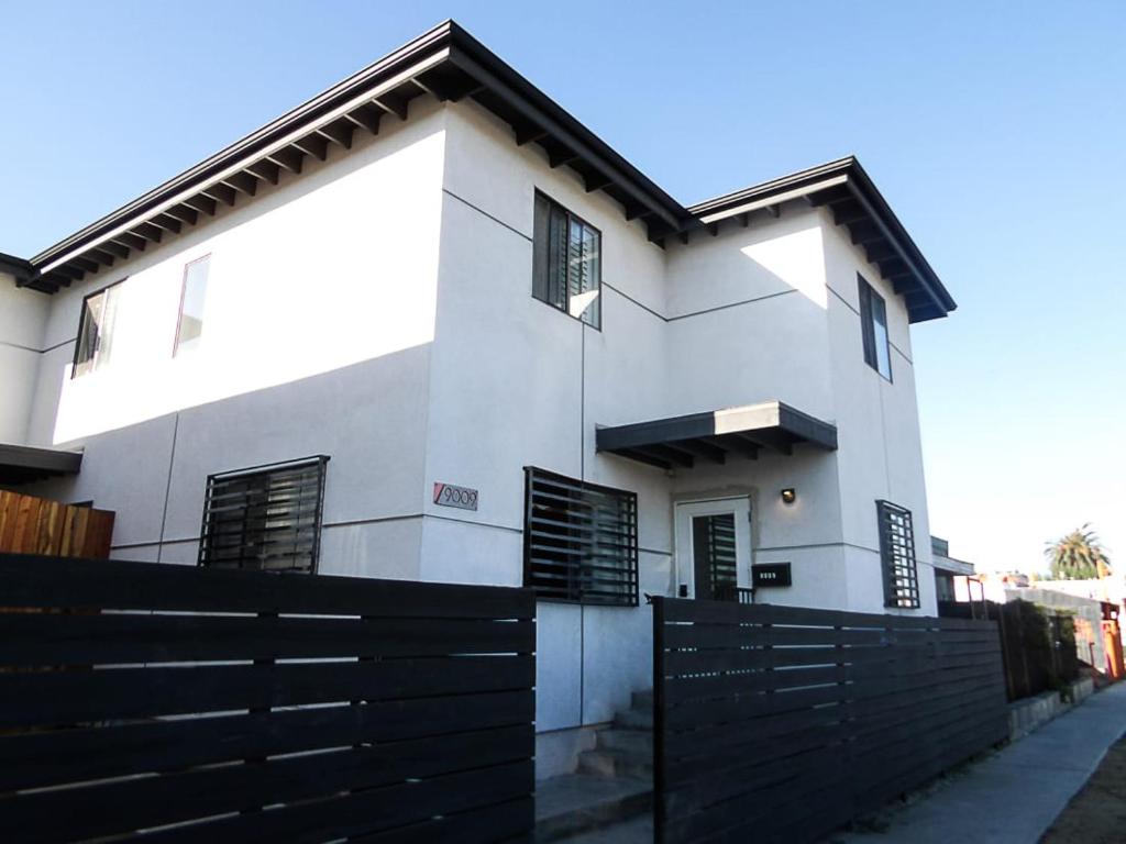 a white house with a black fence in front of it at Normandie Good Vibes Only in Los Angeles