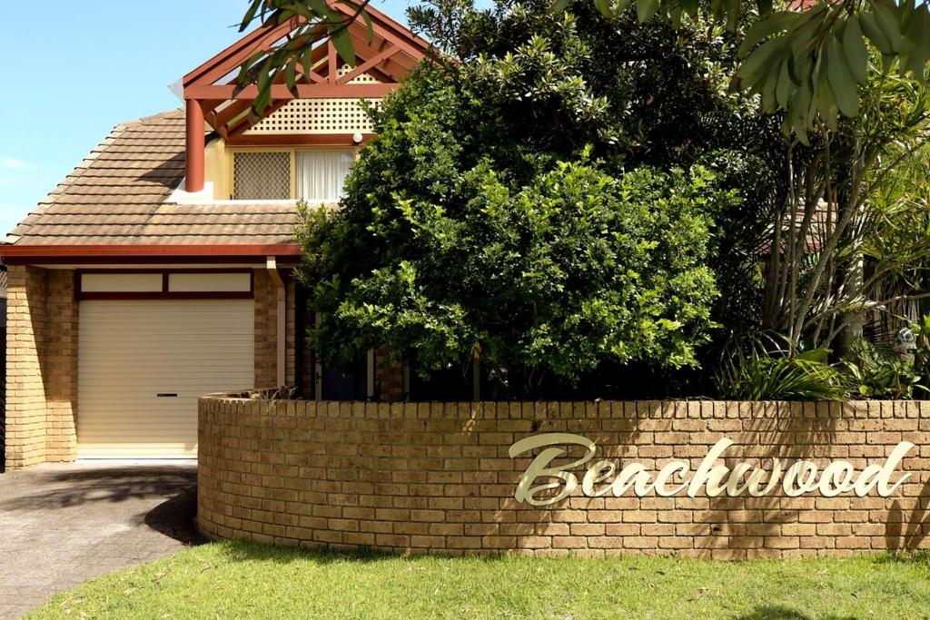 een bakstenen muur voor een huis bij Beach Street - LJHooker Yamba in Yamba