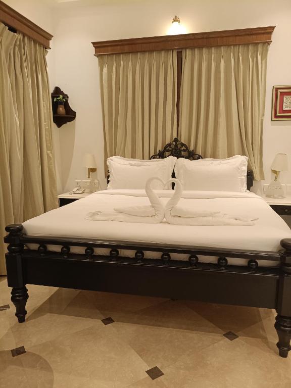 a bedroom with a large bed with two swans on it at The Anthill in Bolpur