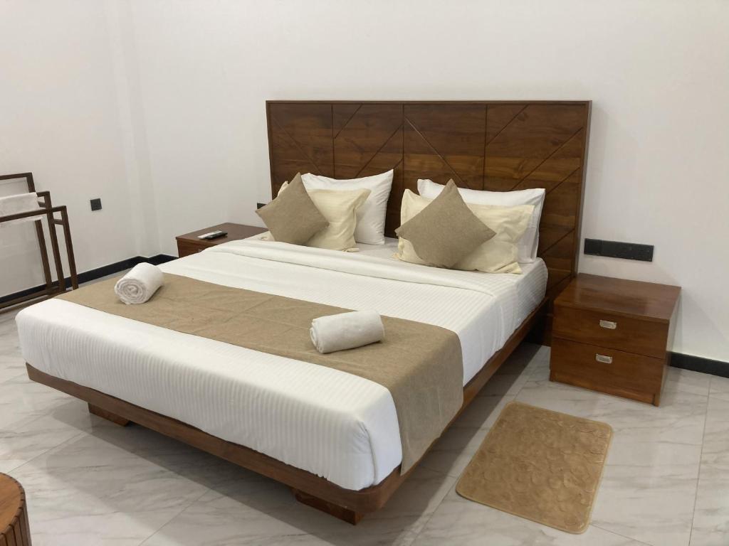 een slaapkamer met een groot bed met een houten hoofdeinde bij Ocean Edge Holiday Resorts in Hiriketiya