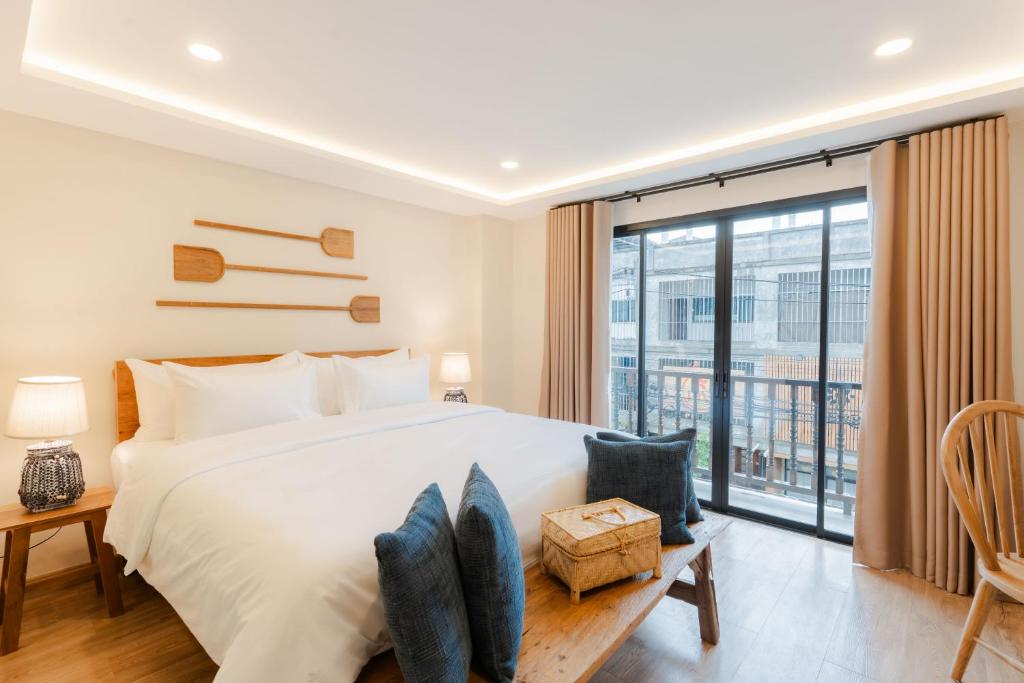 a bedroom with a large bed and a large window at The Tribe Nimman Boutique Hotel in Chiang Mai
