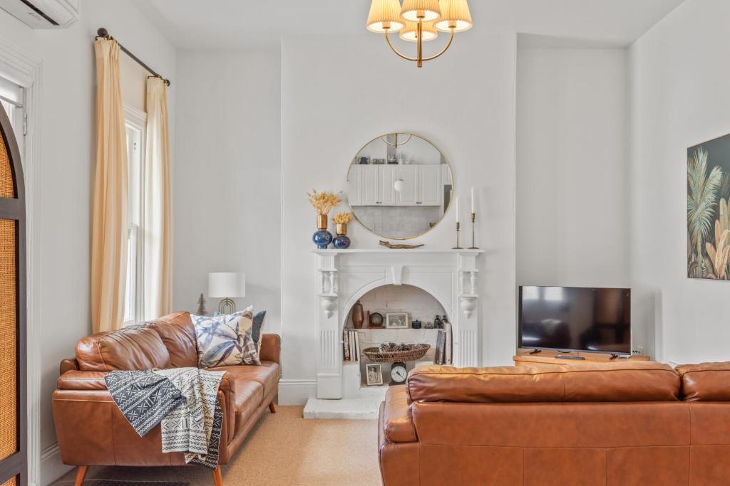 een woonkamer met een bank en een spiegel bij The Countess in Launceston