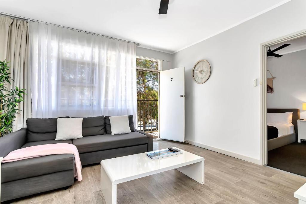 a living room with a couch and a table at Walk to Beach And Cafes Near City And Airport in West Beach