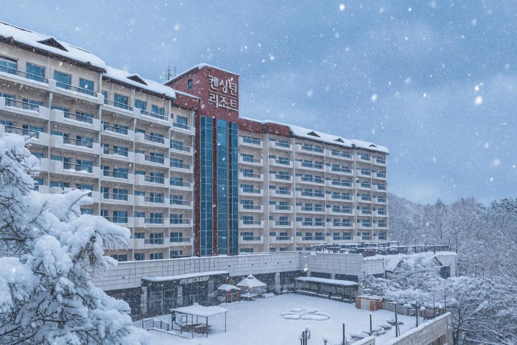 a hotel in the snow in front of a building at Kensington Resort Chungju in Chungju