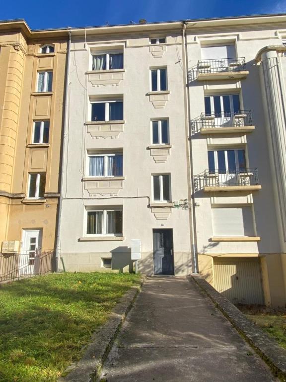 an apartment building with a bench in front of it at Le Saint Symphorien 4 in Longeville-lès-Metz