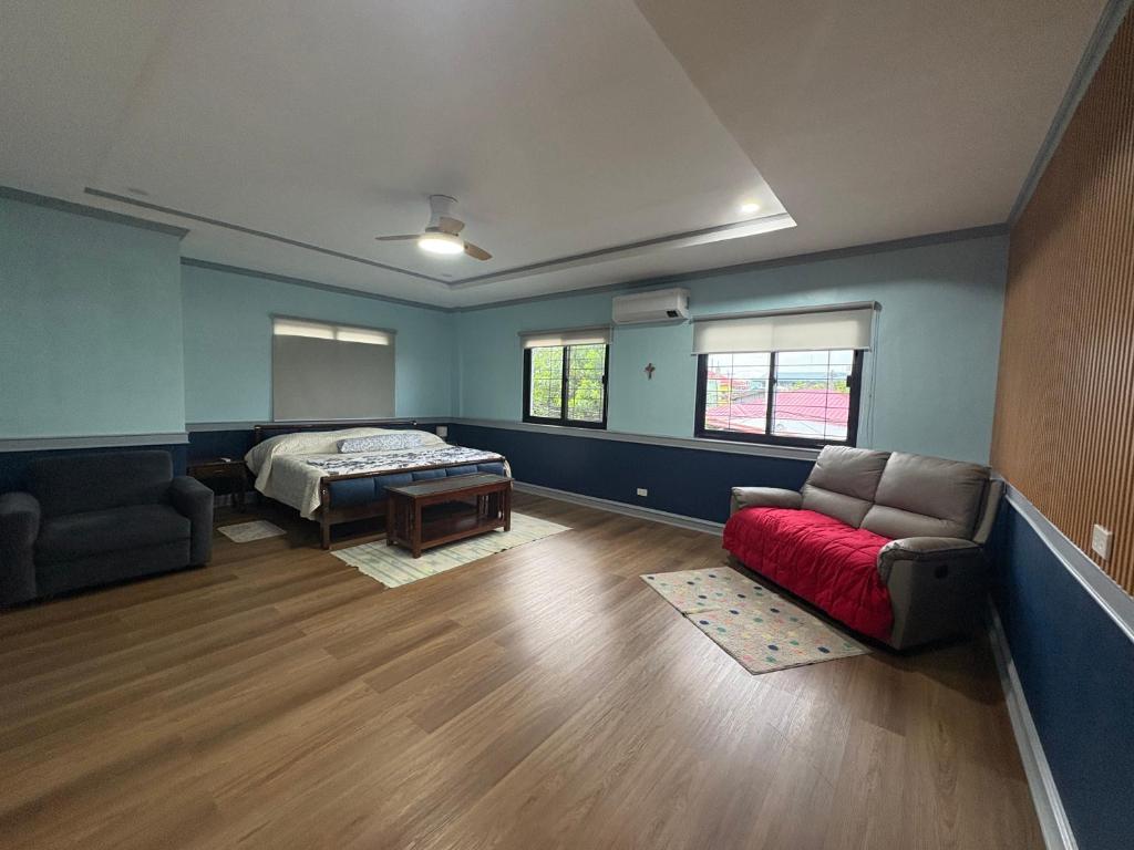 a living room with a bed and a red couch at Palacios Residences in Iloilo City