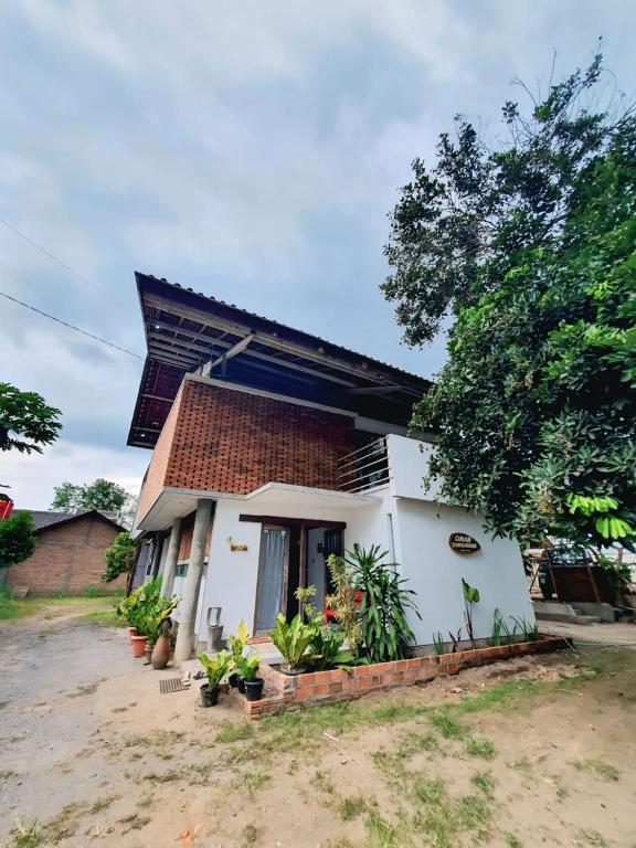 een klein wit huis met een dak bij Omah Jamblangan in Cebongan