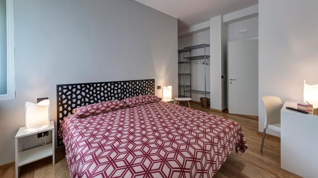 een slaapkamer met een groot bed met een rode sprei bij B&B Villa Giuli in Varese