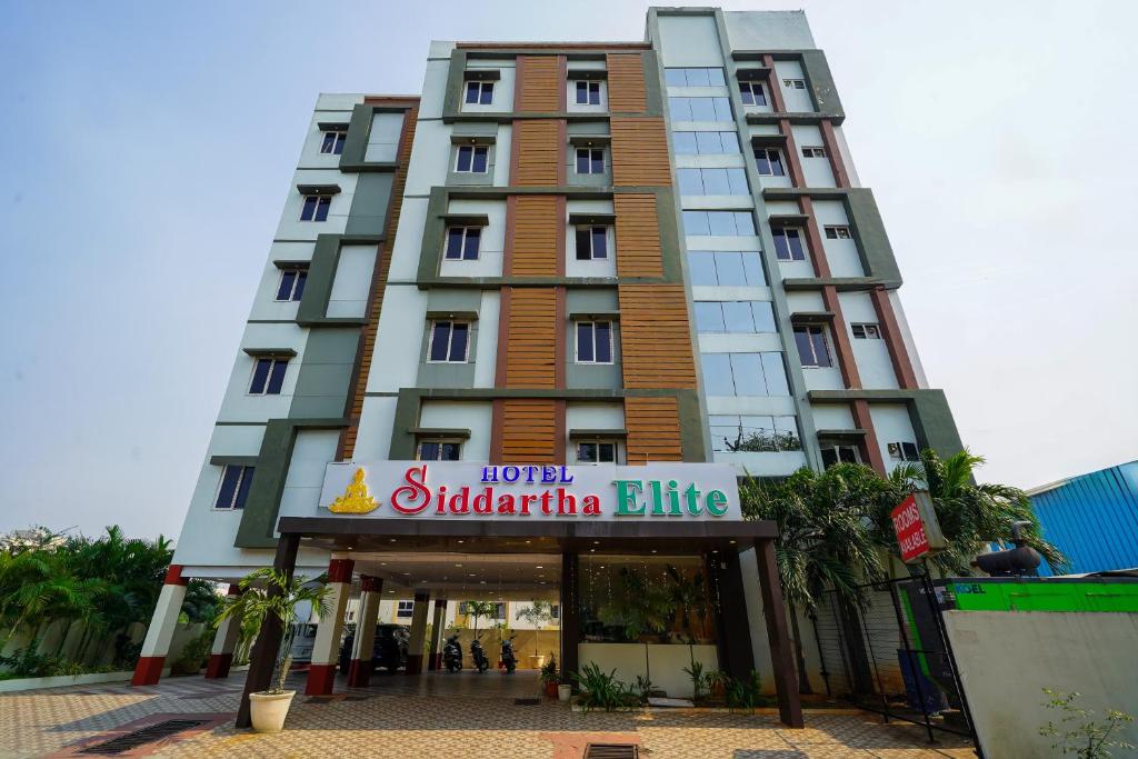 ein hohes Gebäude mit einem Schild davor in der Unterkunft Open Hotel by Olive - Hotel Siddartha Elite in Vijayawada