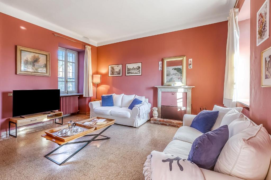 un salon avec deux canapés blancs et une télévision dans l'établissement Villino Maria - Happy Rentals, à Angera