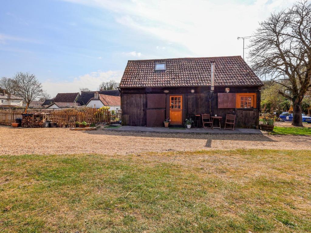 ein kleines Haus mit einer orangefarbenen Tür im Hof in der Unterkunft The Old Tack Room - Uk49233 in Tilshead
