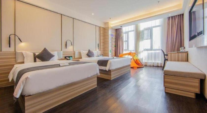 a hotel room with two beds and a couch at Xana Lite Hotel Tianjin National Exhibition Center Jinnan University Town in Tianjin