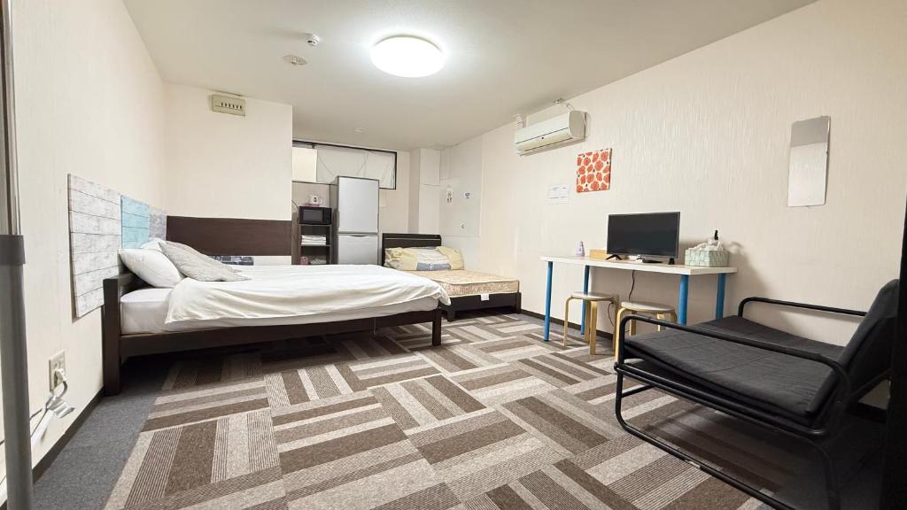 um quarto com uma cama e uma cadeira em 難波南52 em Osaka