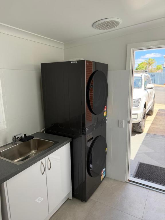 una cucina con un lavello e un frigorifero nero di The Riverbank Suites, Central, New, Facilities a Collie