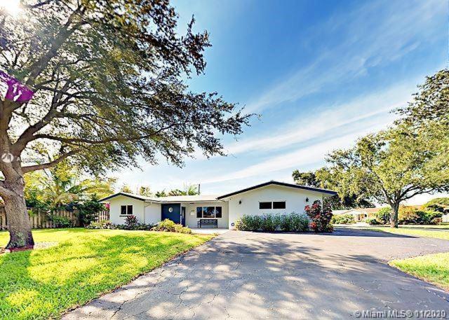 una casa bianca con un albero e un vialetto di The Chill Crib a Fort Lauderdale