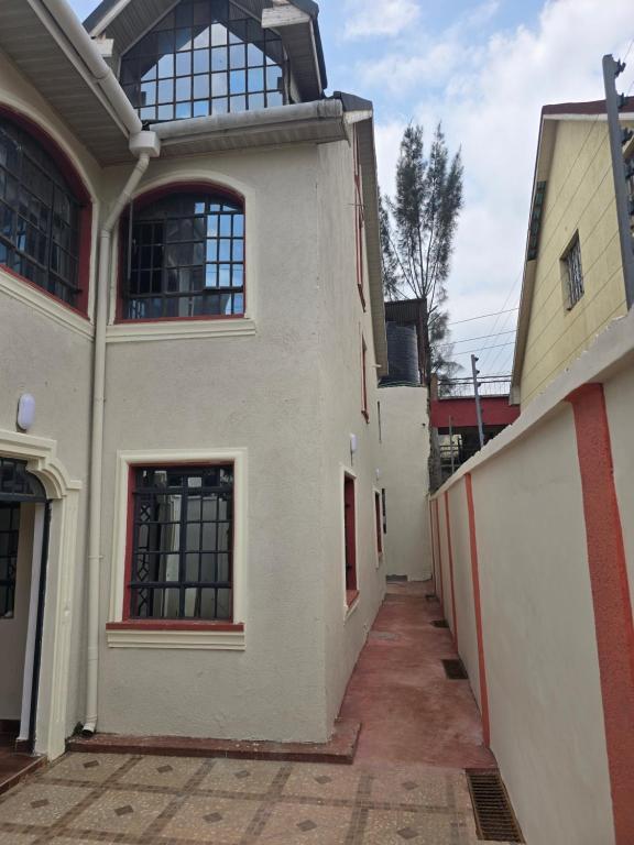 een wit gebouw met ramen aan een straat bij Safaripark Gardens in Nairobi