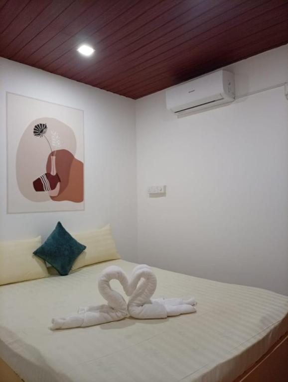 a white bed with a heart shaped towel on it at Airport Transit Motel in Katunayaka