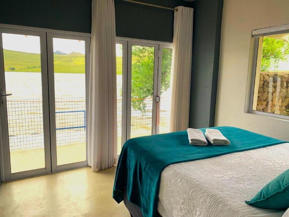 een slaapkamer met een bed en een raam met uitzicht bij The Boathouse in Harrismith