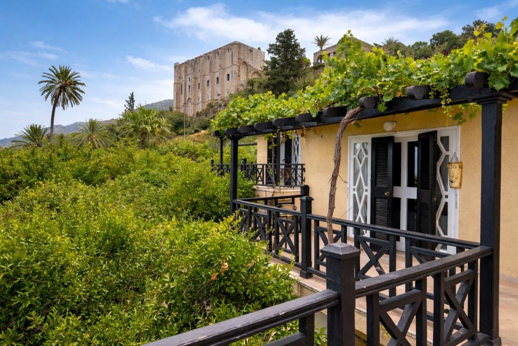 una casa con balcón con un edificio al fondo en Bellapais Gardens, en Kyrenia