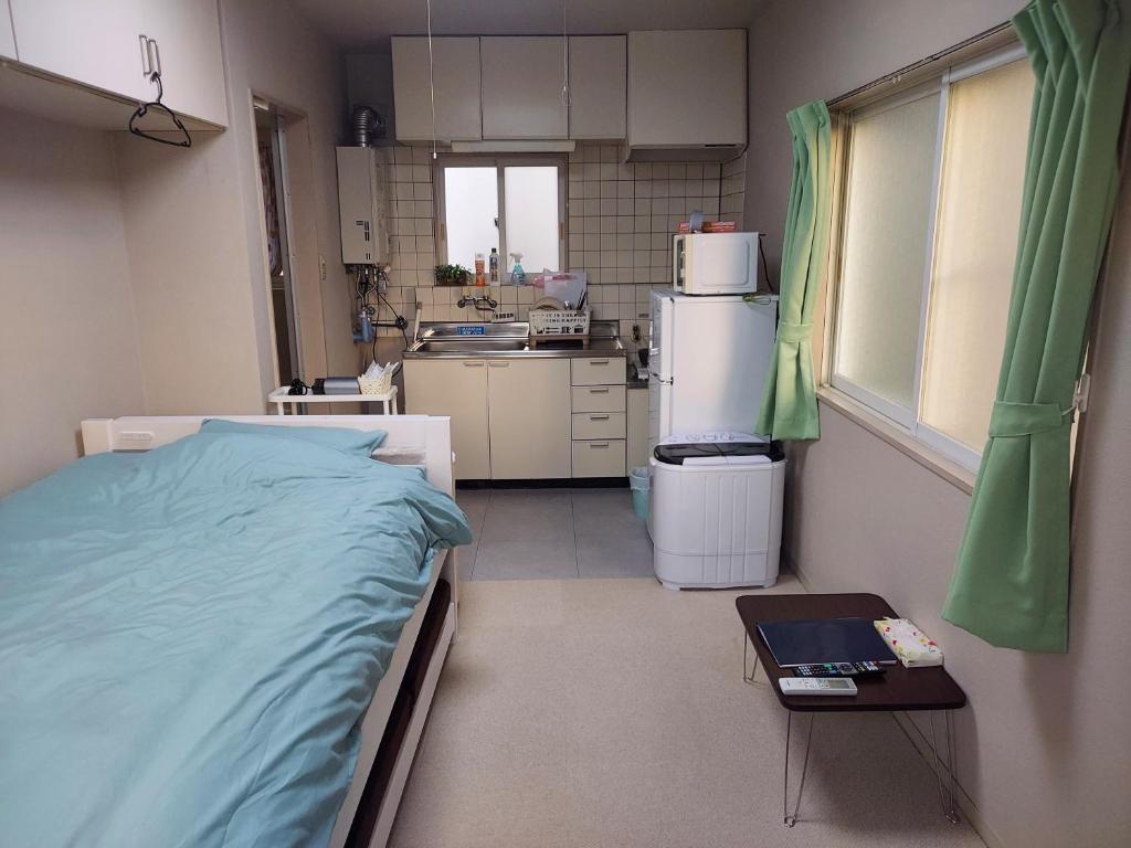 Una habitación de hospital con una cama y una cocina. en トリトン茶屋町#201#202, en Aomori