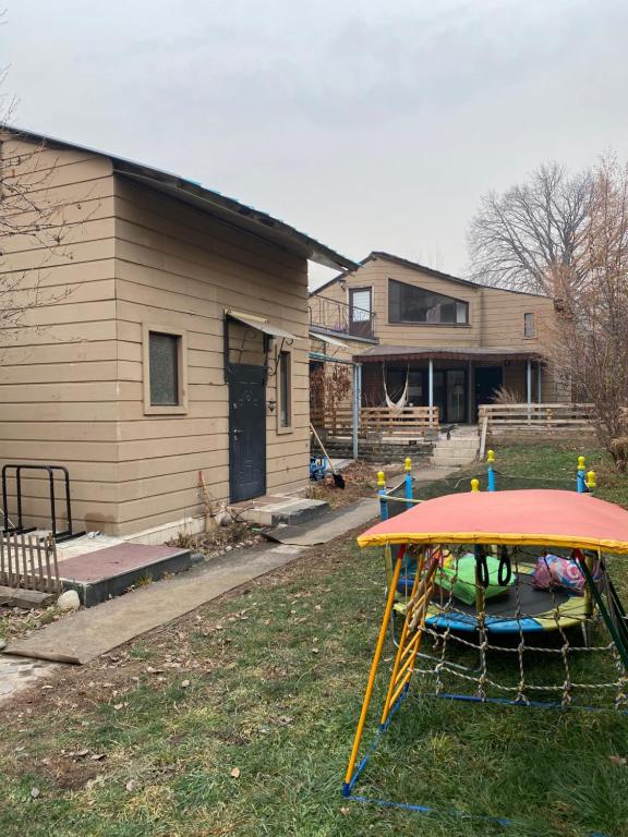 a backyard with a table in the yard with a house at Leonovs in Almaty