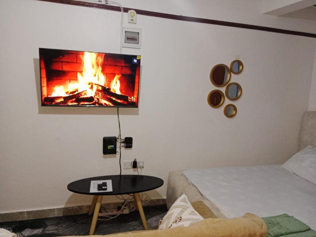 Elle comprend un salon avec une cheminée et une télévision murale. dans l'établissement Haven's spot, à Mombasa