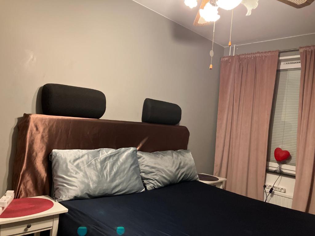 um quarto com uma cama com uma cabeceira e uma janela em Privat room with 160 bed near Arlanda Airport em Märsta