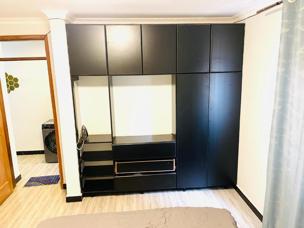 a bedroom with a large black cabinet at Zuri stays in Kampala