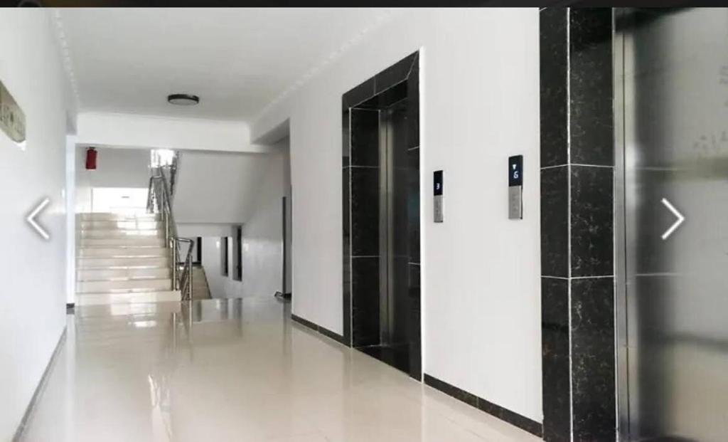 een gang met zwart-witte muren en een zwarte deur bij Sky Vista Homes in Nairobi