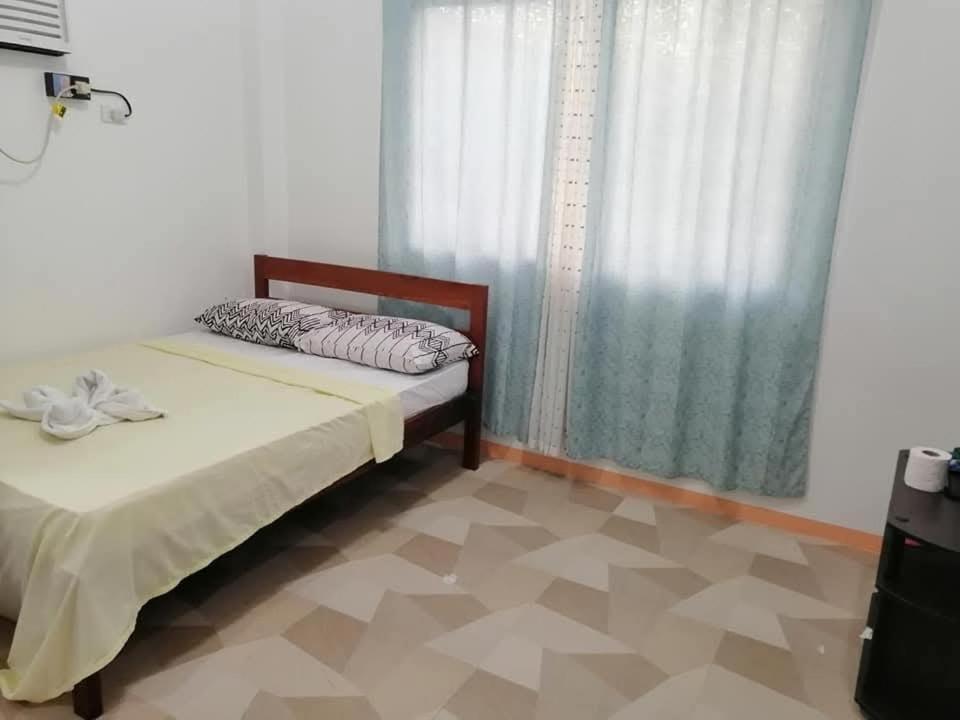 ein Schlafzimmer mit einem Bett und einem Fenster in der Unterkunft J and J Residence in General Luna