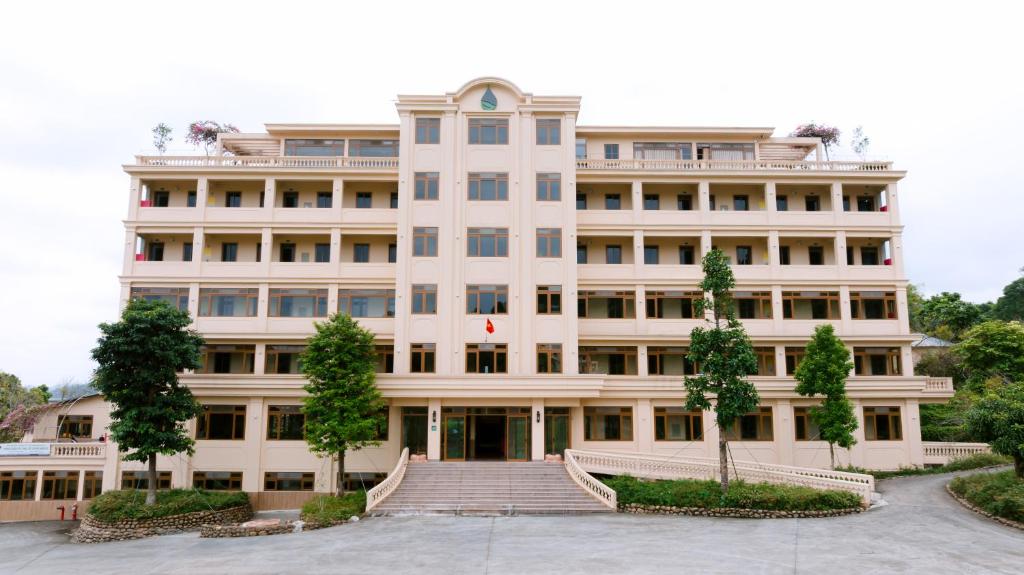 een groot wit gebouw met een trap ervoor bij Baviecoresort in Ba Vì