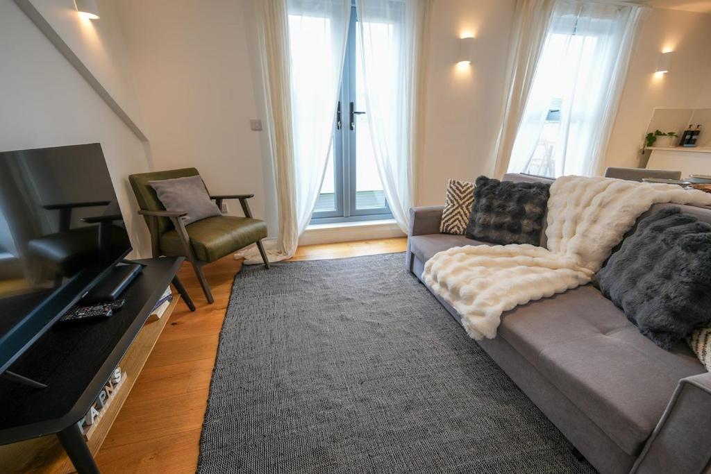 ein Wohnzimmer mit Sofa und Fernseher in der Unterkunft The Sea Pearl in Eastbourne