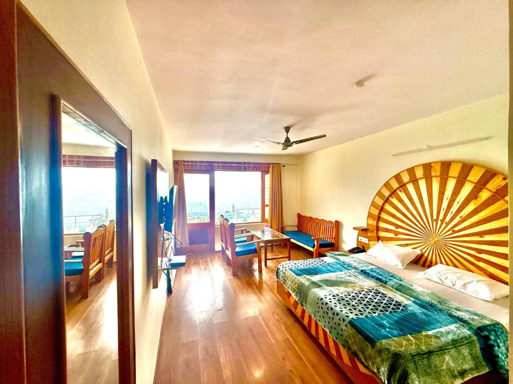a bedroom with a large bed with a large fan at Cedar Valley Retreat in Jagatsukh