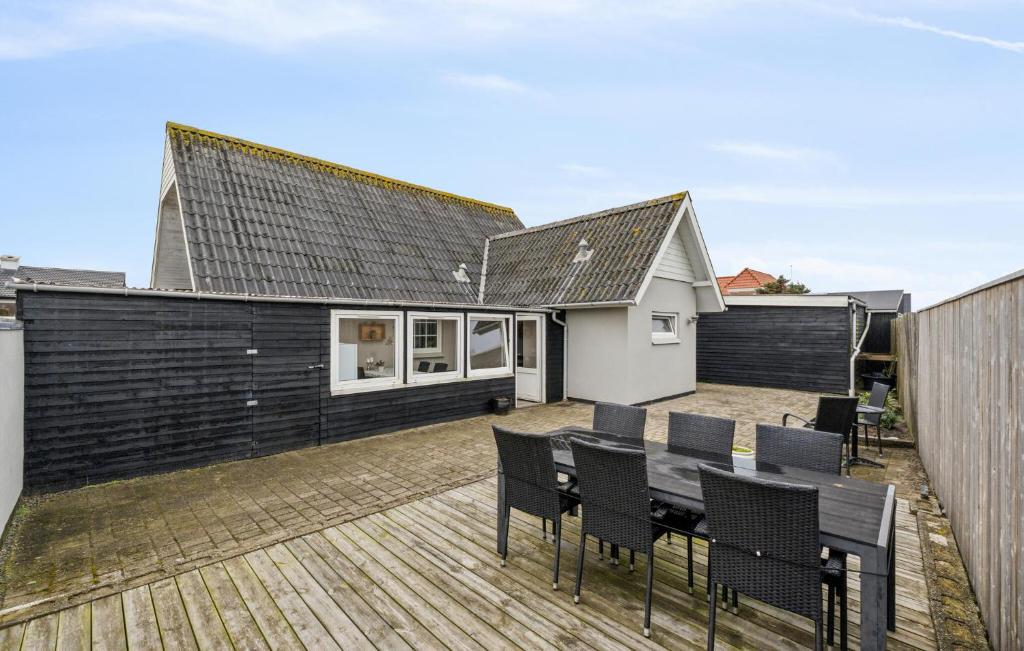 a house with a deck with a table and chairs at Nice Home In Thyborøn With Wifi in Thyborøn