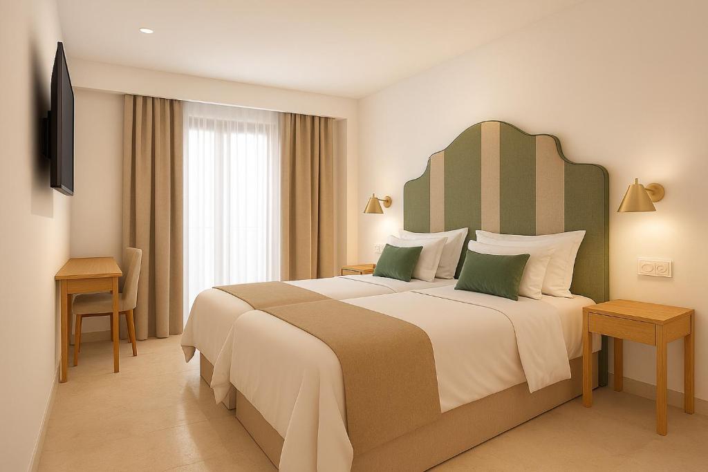 een hotelkamer met een groot bed en een televisie bij Hotel Boutique Petit París in Port de Pollença