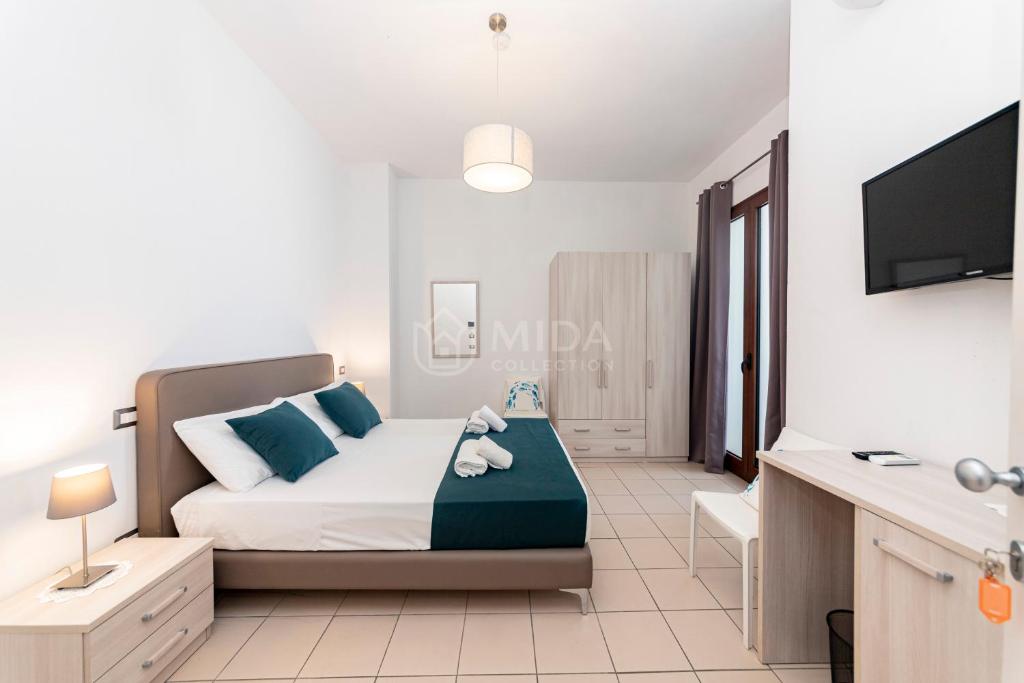 a bedroom with a bed and a flat screen tv at Mama Bed in Porto Cesareo