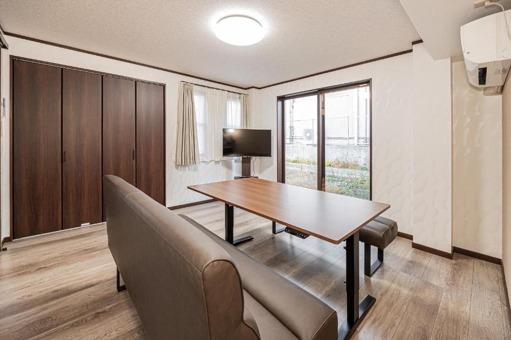 a dining room with a table and a couch at 富士飛鳥 in Fujiyoshida