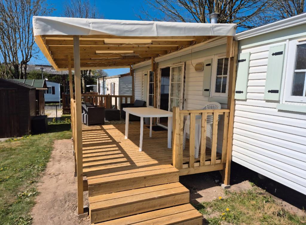 Markise über einer Terrasse auf einem winzigen Haus in der Unterkunft Mobil-home camping Le Ptit Rio in Noyelles-sur-Mer