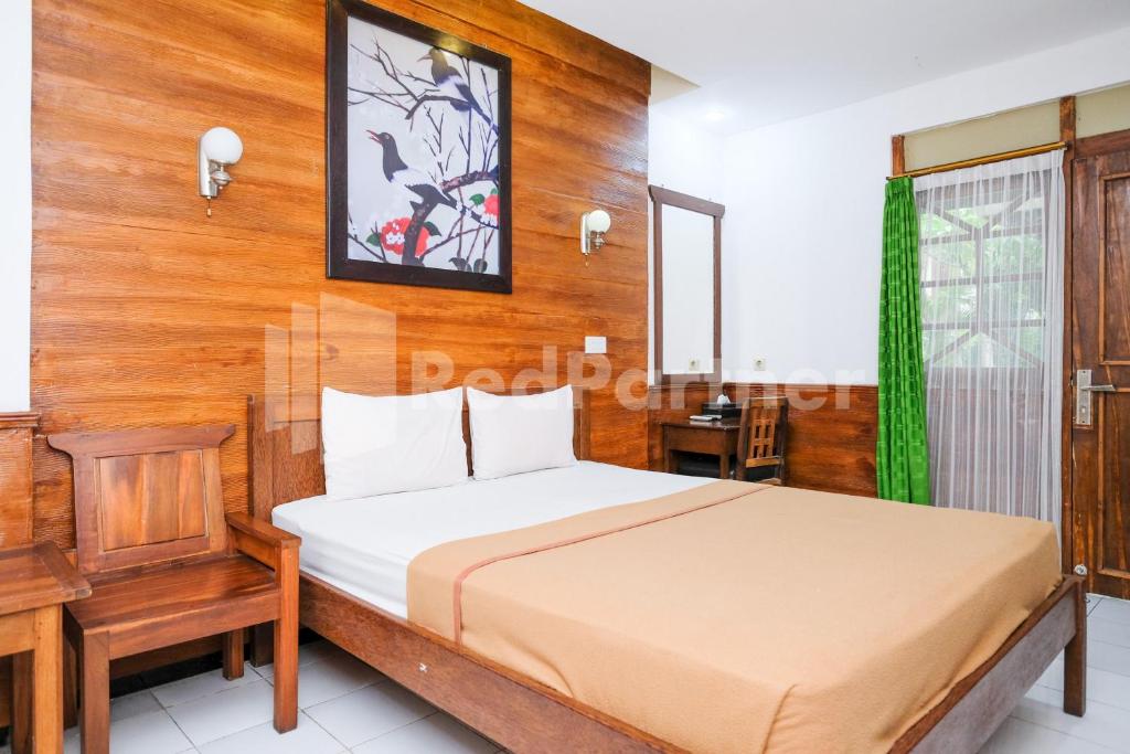 a bedroom with a bed and a wooden wall at The Soemarsono Hotel near Ambarrukmo Plaza Mall RedPartner in Yogyakarta