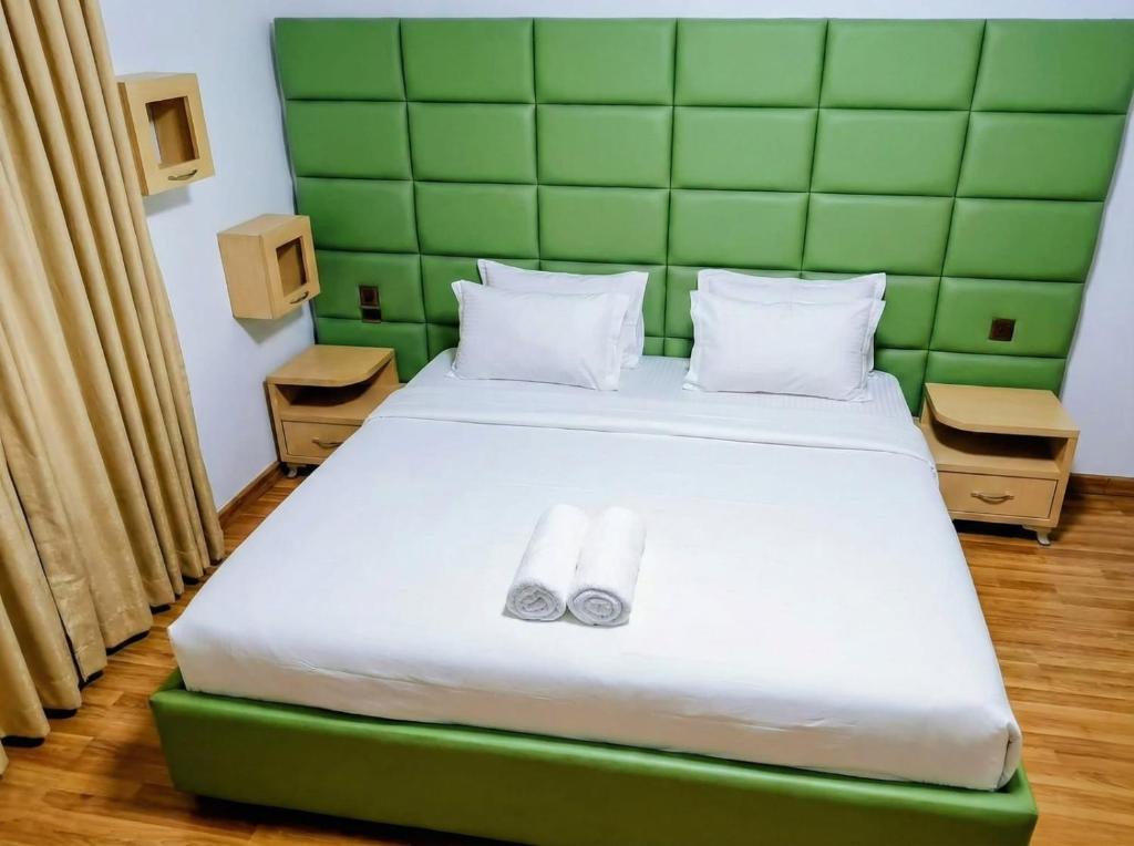 een slaapkamer met een bed met twee slippers erop bij Urban Artist in Tirana