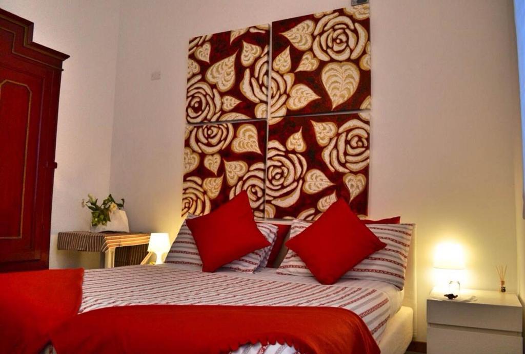 a bedroom with a bed with a headboard with red pillows at B&B Annabel in Milan