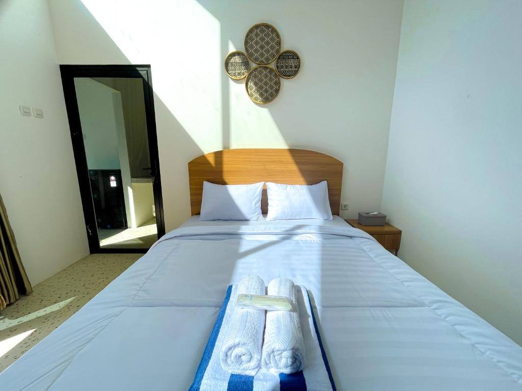 ein Schlafzimmer mit einem Bett, auf dem zwei Handtücher liegen in der Unterkunft Oasis Montana Jogja in Ngemplak