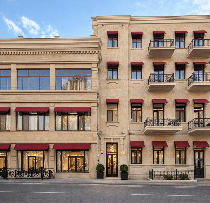 an apartment building with red awnings at Maestro Address Baku Hotel in Baku