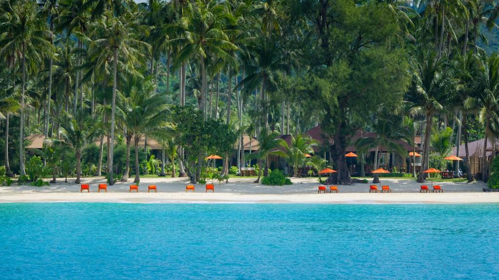 una playa con sillas y sombrillas en la arena en Medee Resort, en Ko Kood