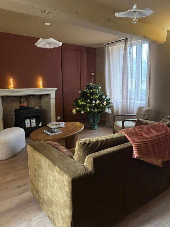 a living room with a couch and a table and a fireplace at La Maison des Chouettes in Maisons-lès-Chaource