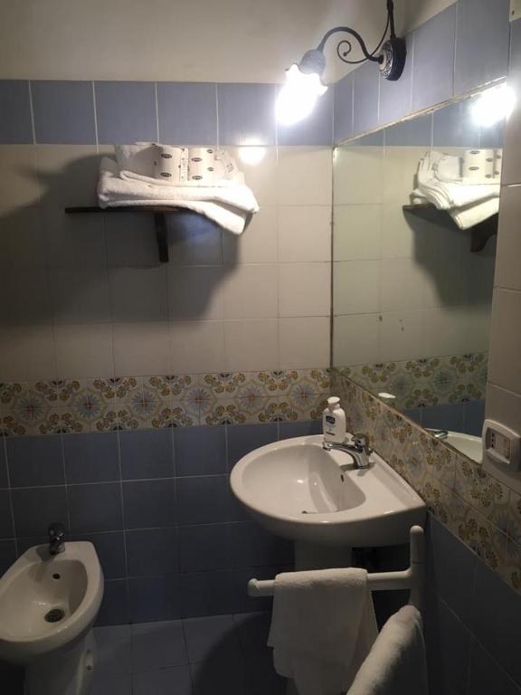 a bathroom with a sink and a toilet at Azzurromare Residence in Procida