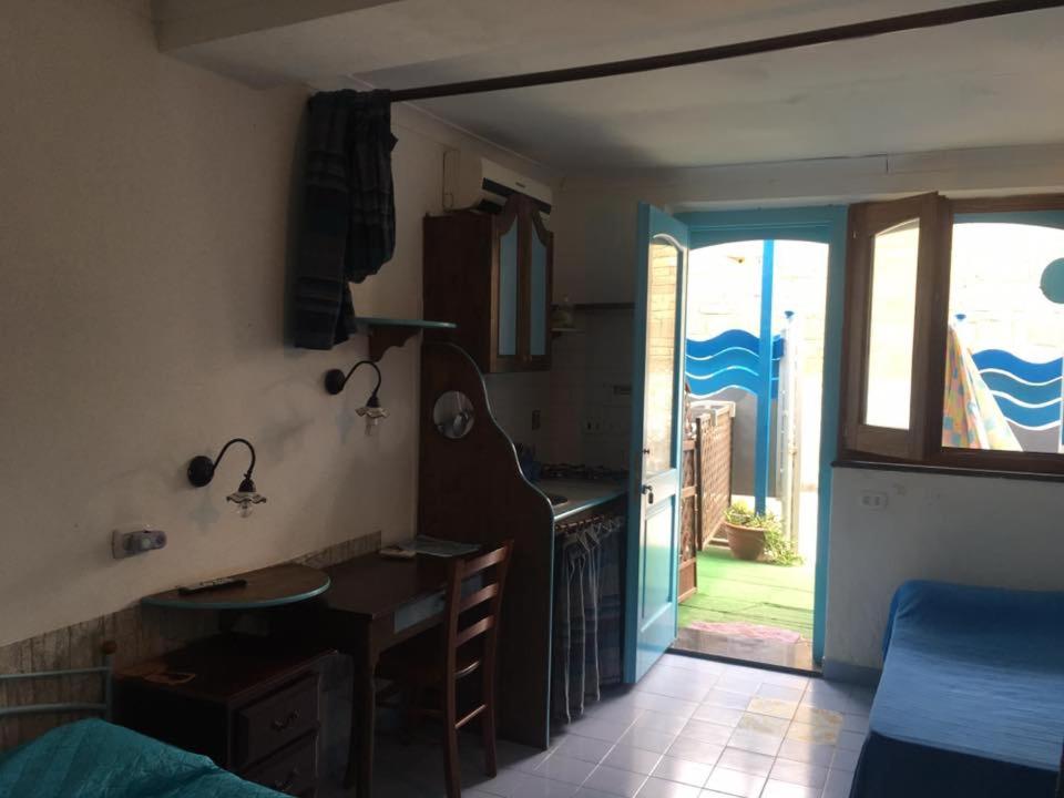 a room with a kitchen and a desk and a table at Azzurromare Residence in Procida
