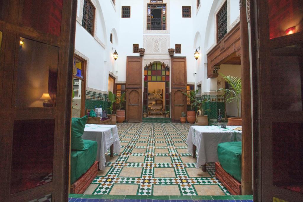 a room with tables and chairs in a building at Riad Ruh Fes in Fez